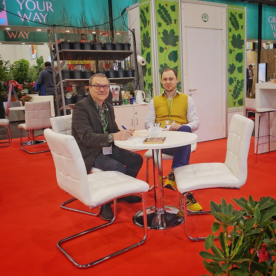 Wiesław Szydło i Grzegorz Falkowski ze Związku Szkółkarzy Polskich siedzą przy stoliku podczas wystawy IPM Essen 2023